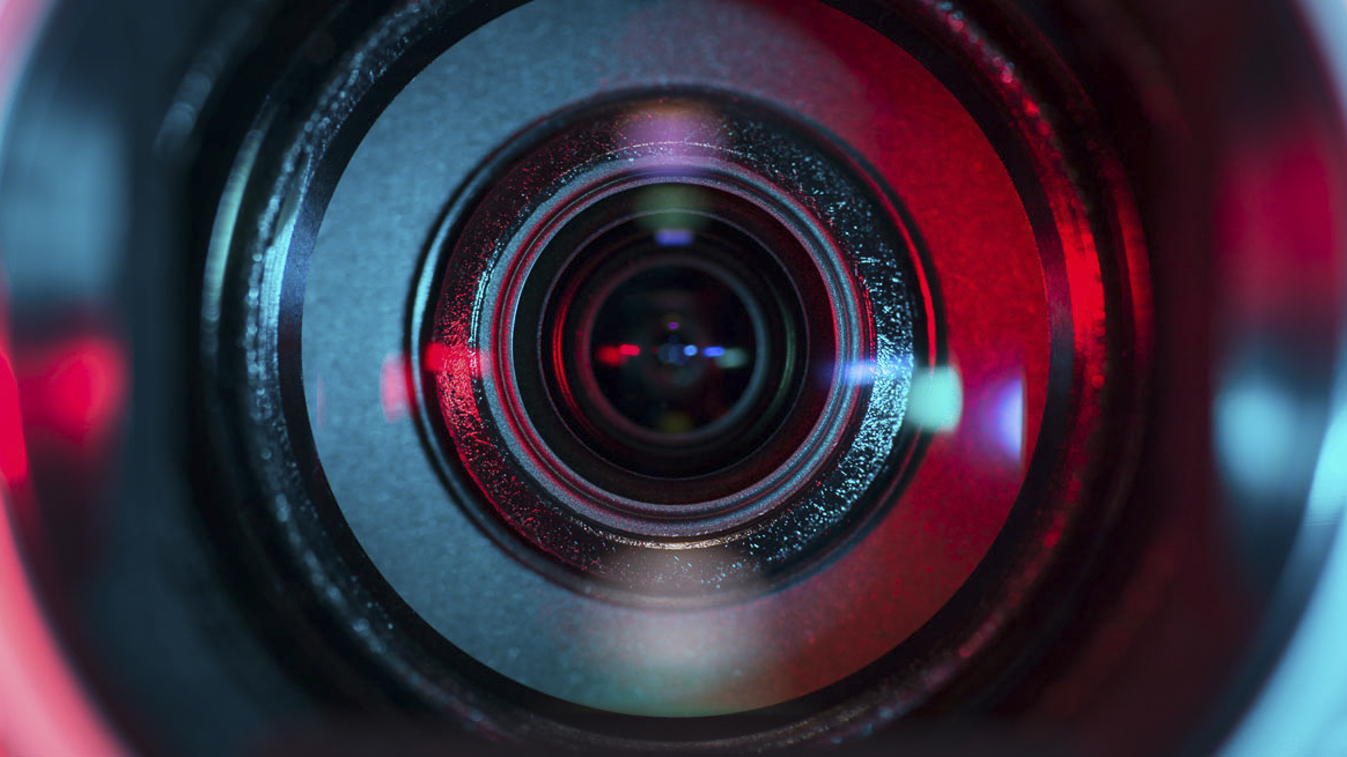Close-up of a camera lens with colorful reflections and light effects.